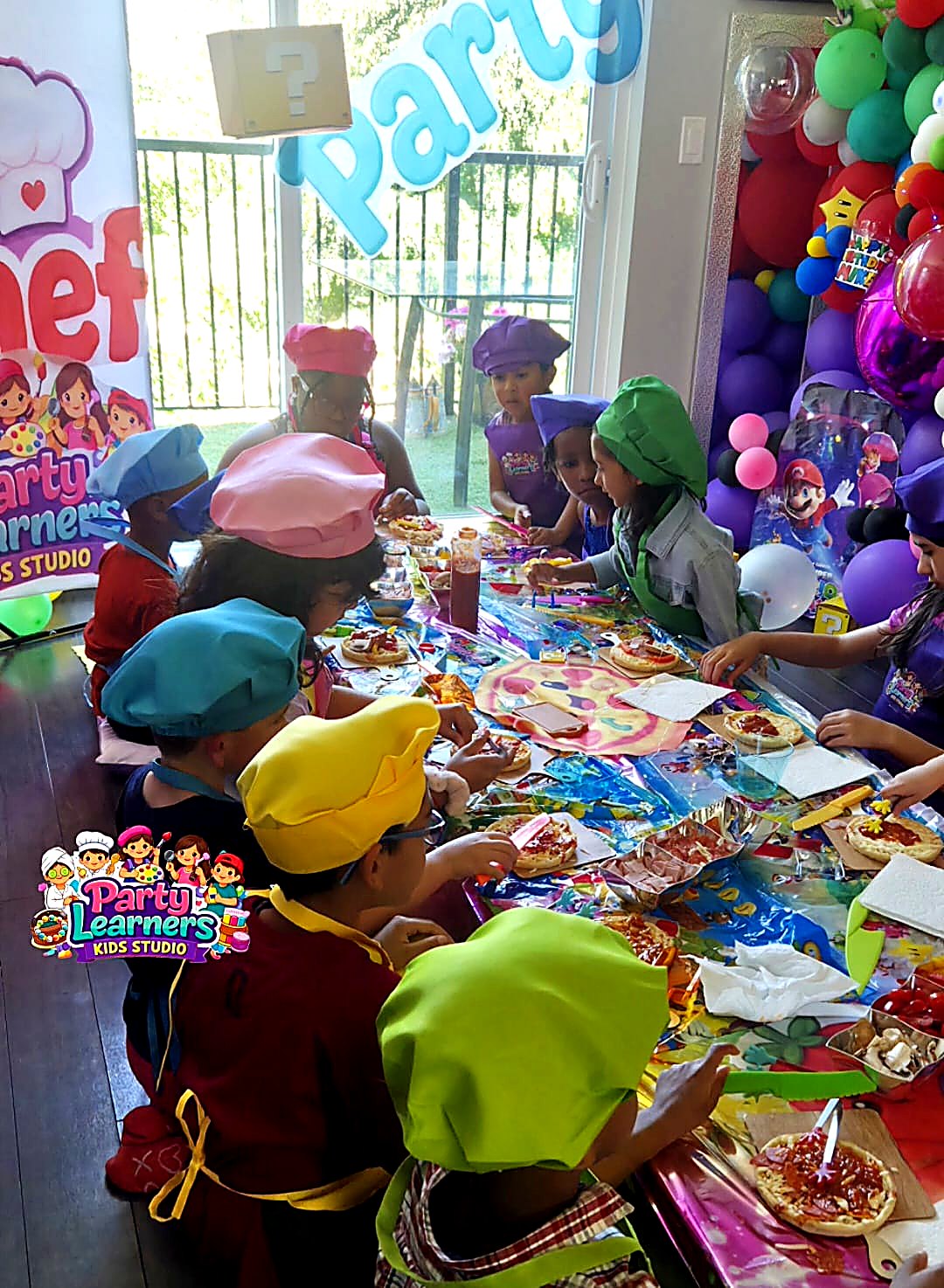 Kids in chef hats and aprons decorating their mini pizzas at a Chef Party — Decorating Experience