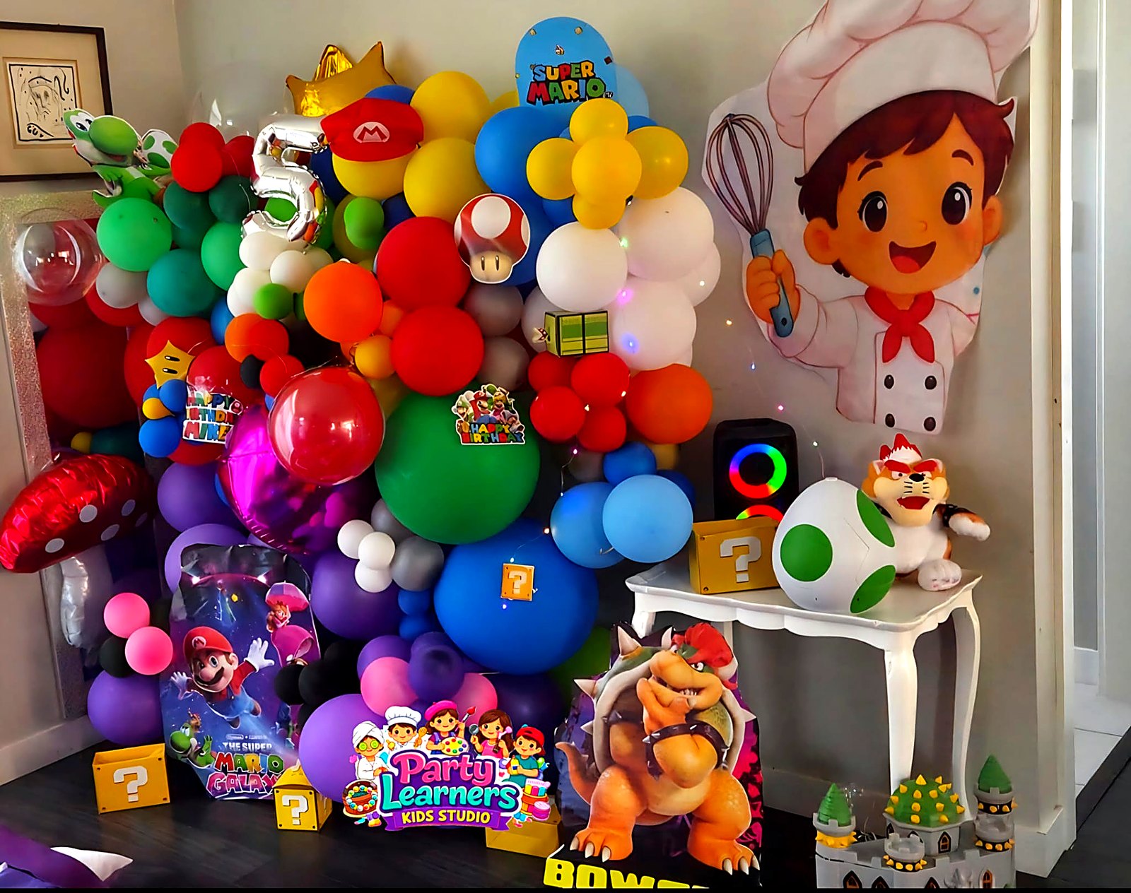 Mario-themed balloon arch with chef cutout and decorating-table setup at a Chef Party — Decorating Experience by Party Learners Kids Studio