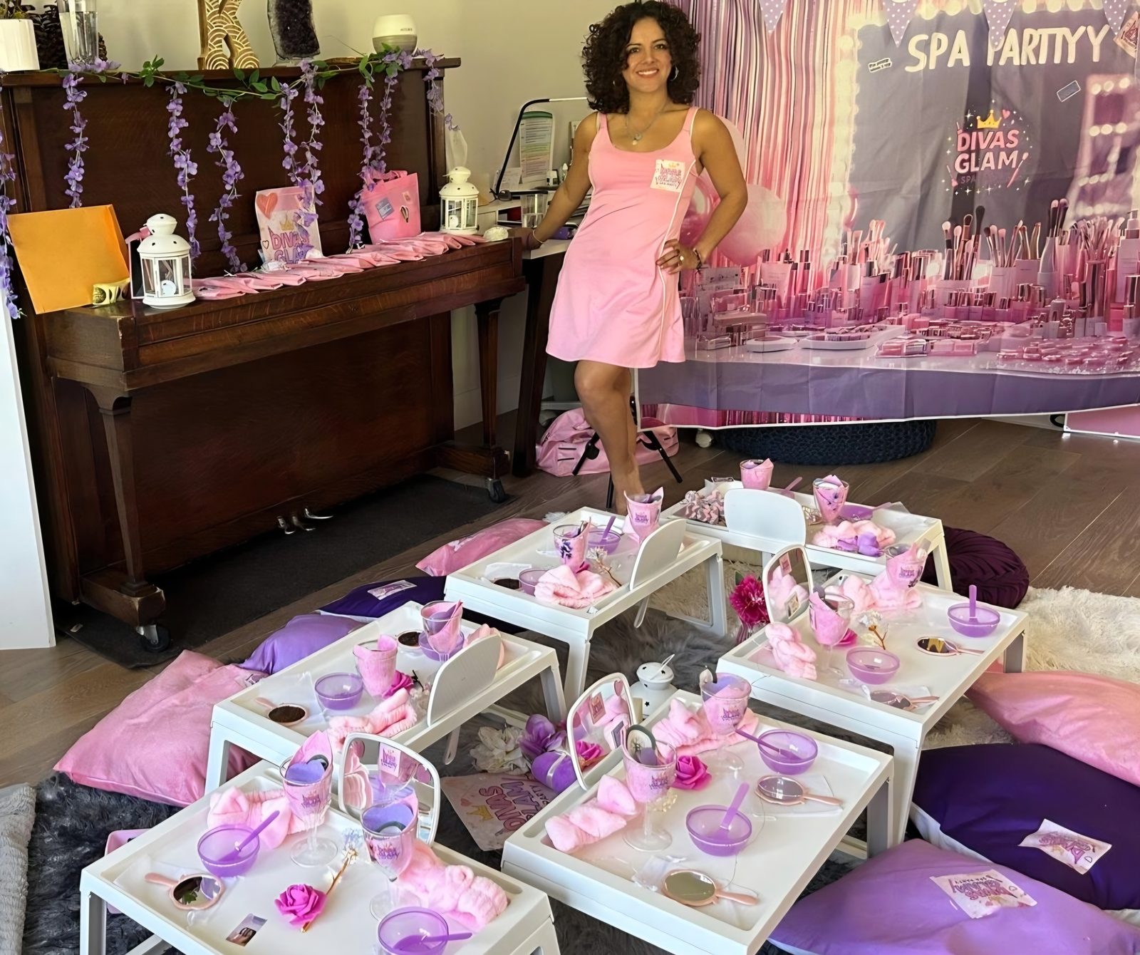 Divas Glam Spa Party setup with purple and pink table arrangement, light-up trays, piano and DIVAS GLAM SPA PARTY backdrop, hosted by Party Learners Jenn