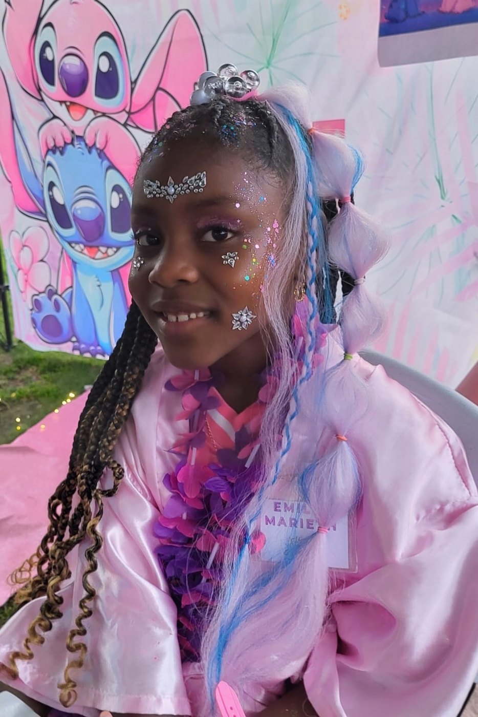 Birthday girl with face gems and themed hair extensions at a Divas Glam Spa Party