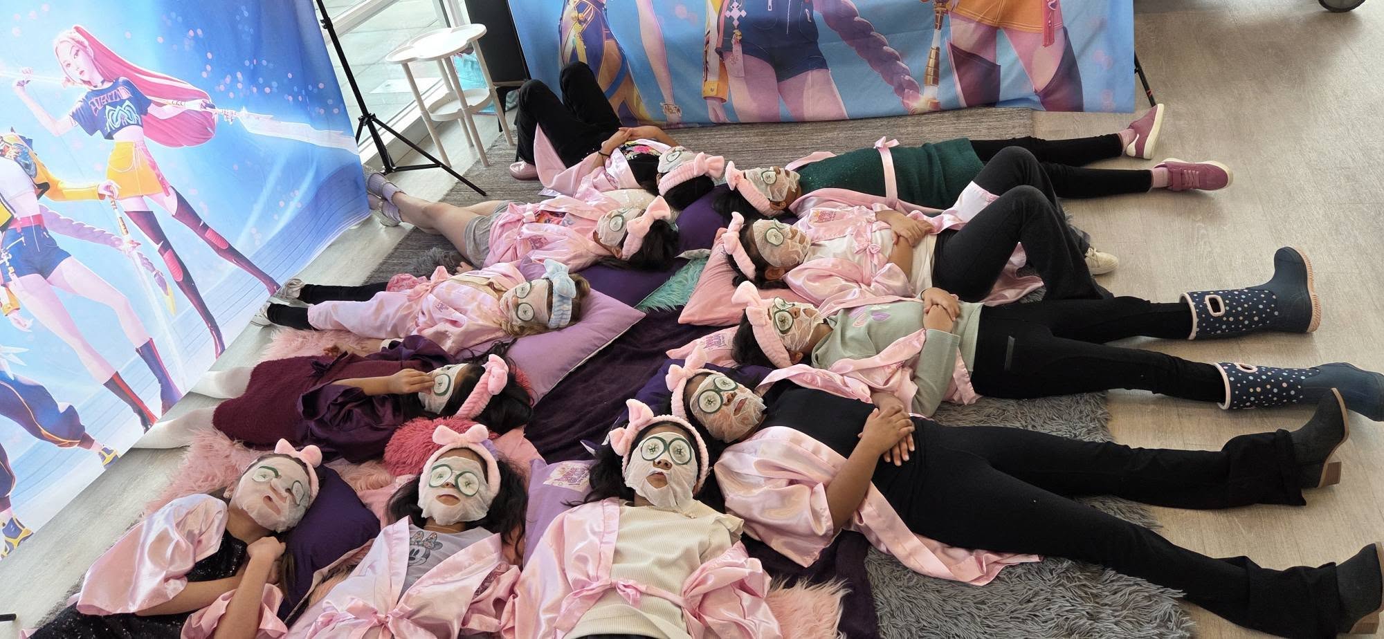 Group of girls in pink robes relaxing with face masks at a Divas Glam Spa Party