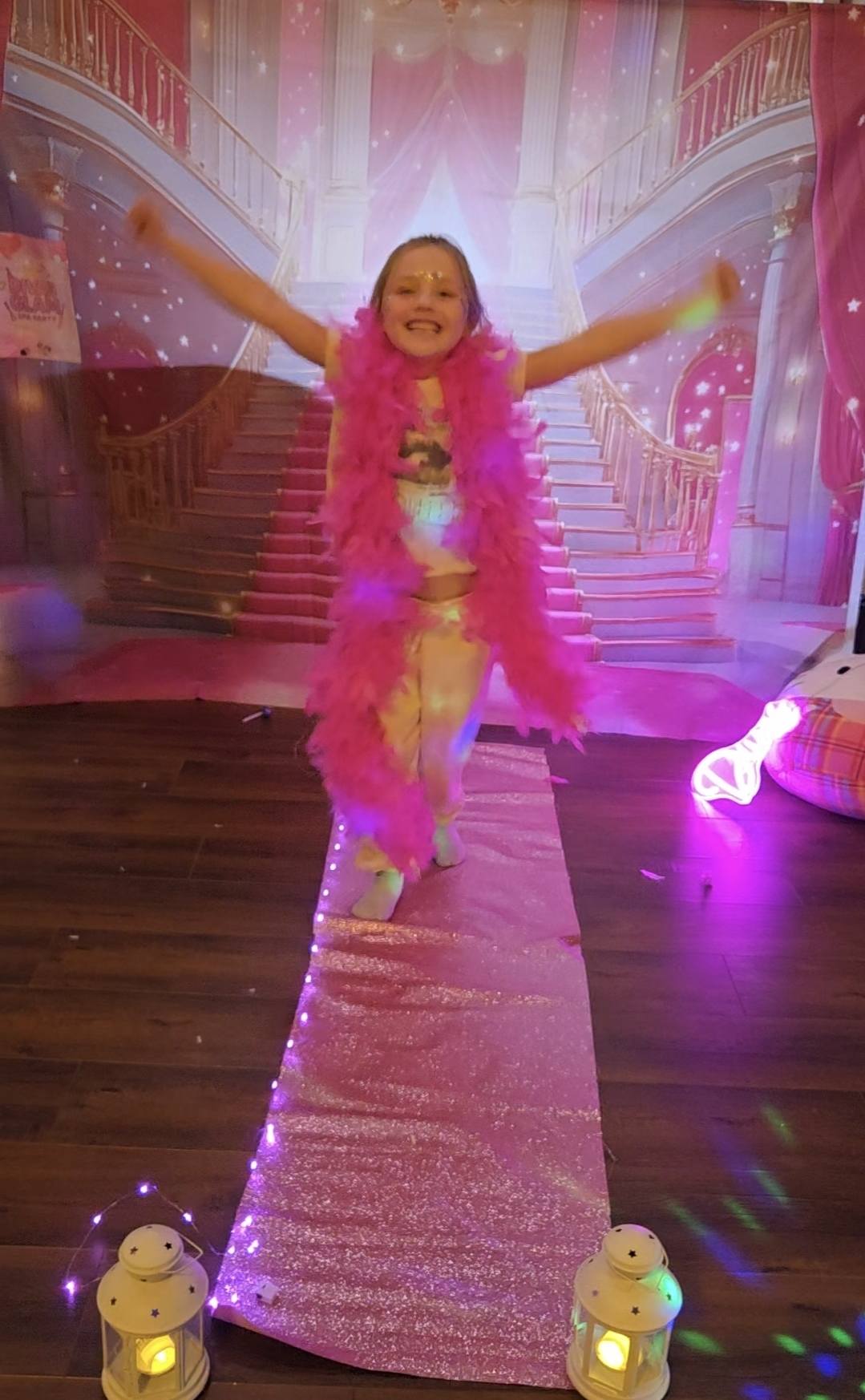 Birthday girl celebrating her runway moment with a pink feather boa at a Divas Glam Spa Party