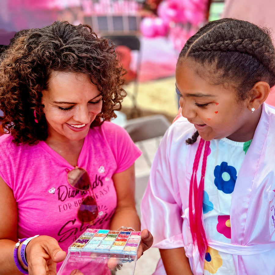 Jenn with a young guest discovering glitter and beauty supplies during a Divas Glam Spa Party