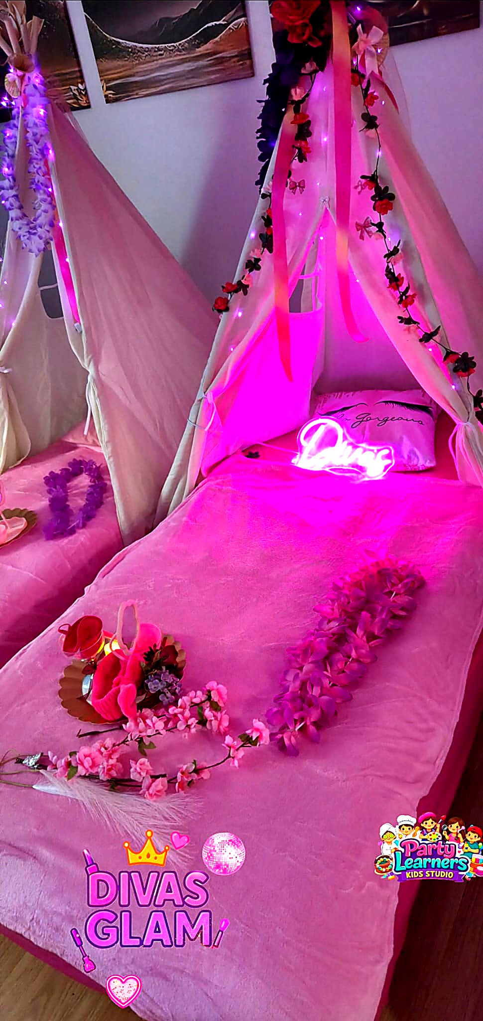 Close-up of a single Slumber Party teepee with cozy pink bedding, flower garlands and soft lighting