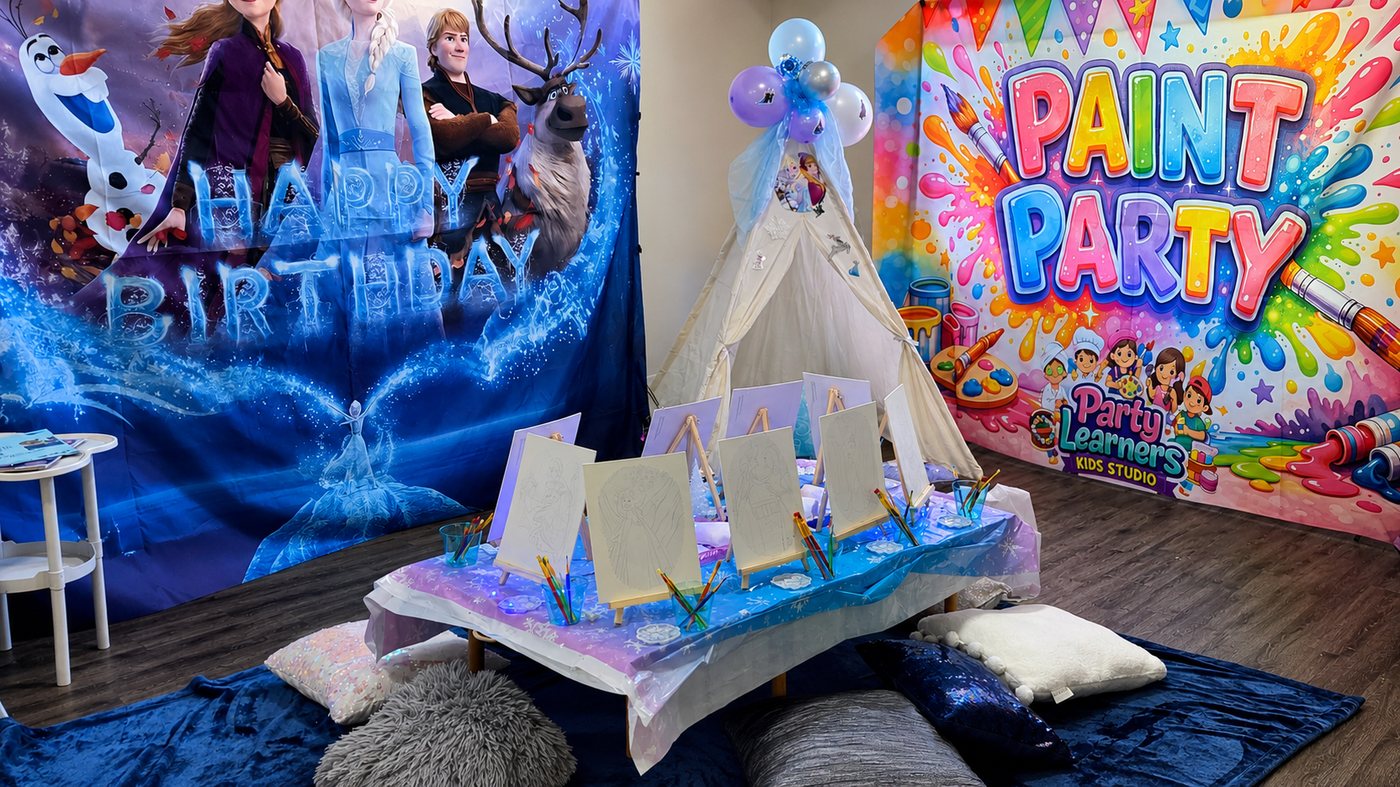 Frozen-inspired Paint Boho Party + Craft setup with Frozen Happy Birthday backdrop, white tipi, easels with canvases and PAINT PARTY backdrop at Party Learners Kids Studio