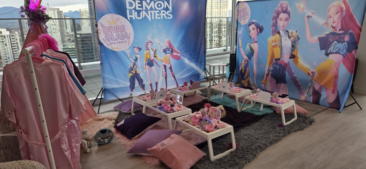Demon Hunters themed Divas Glam Spa Party setup with K-Pop backdrop, robes rack and spa trays