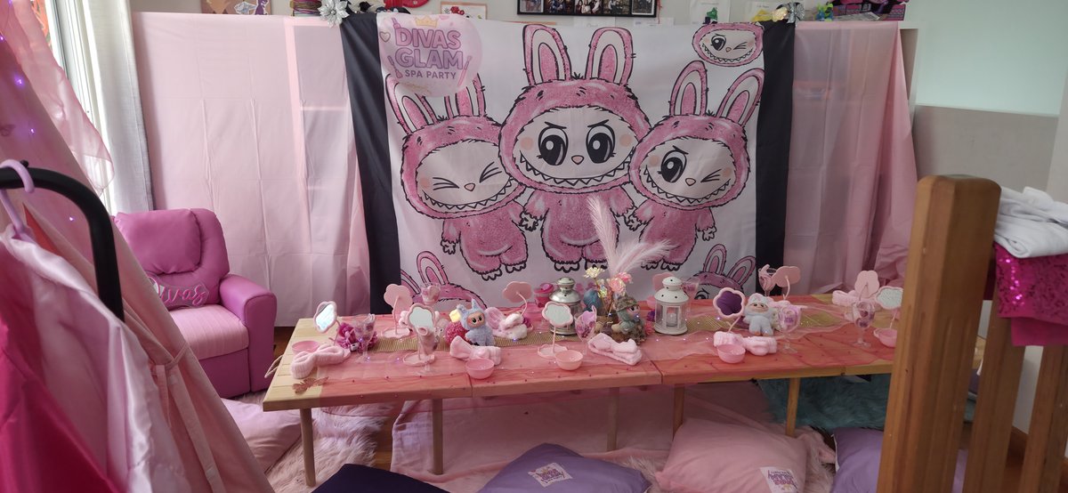 Labubu themed party setup with pink bunny backdrop and treat-filled table
